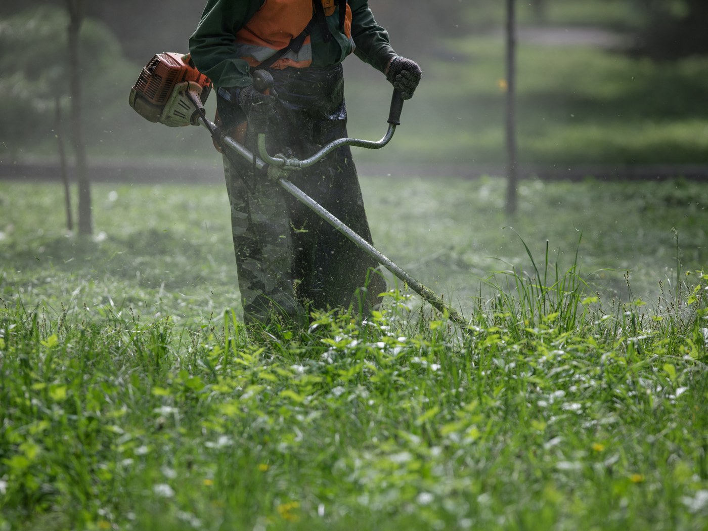 Débroussailleuse thermique utilisée dans une herbe haute